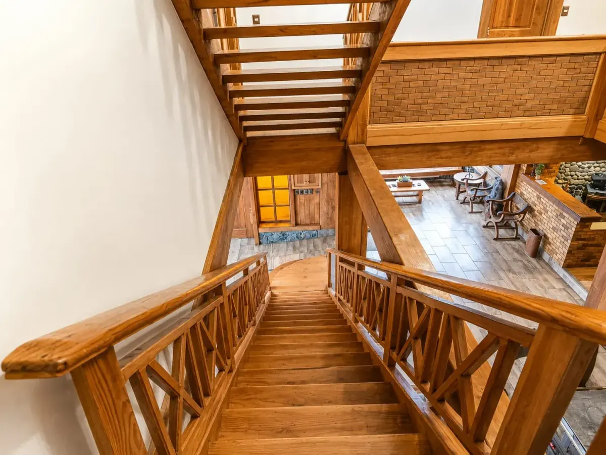 Escalera interior de madera que conecta los niveles de la casona con vista al altillo